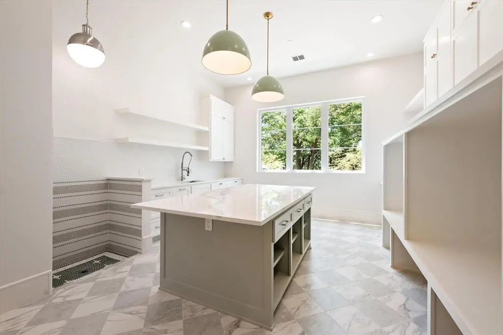 3211 Wintergreen Terrace boasts a functional laundry with ample built-ins and a pet washing shower.