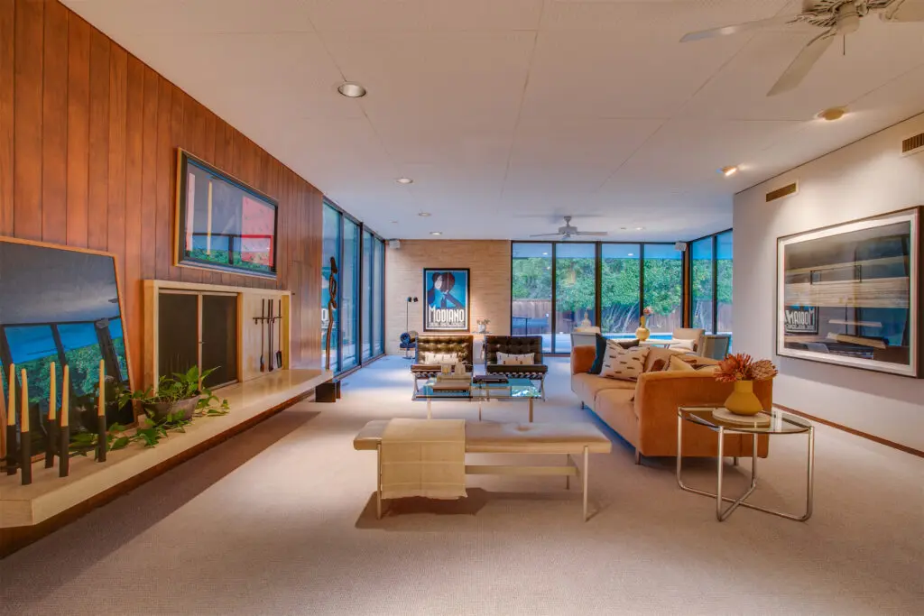 Another spacious living area with custom cabinetry, wood-paneling, and floor-to-ceiling windows. 