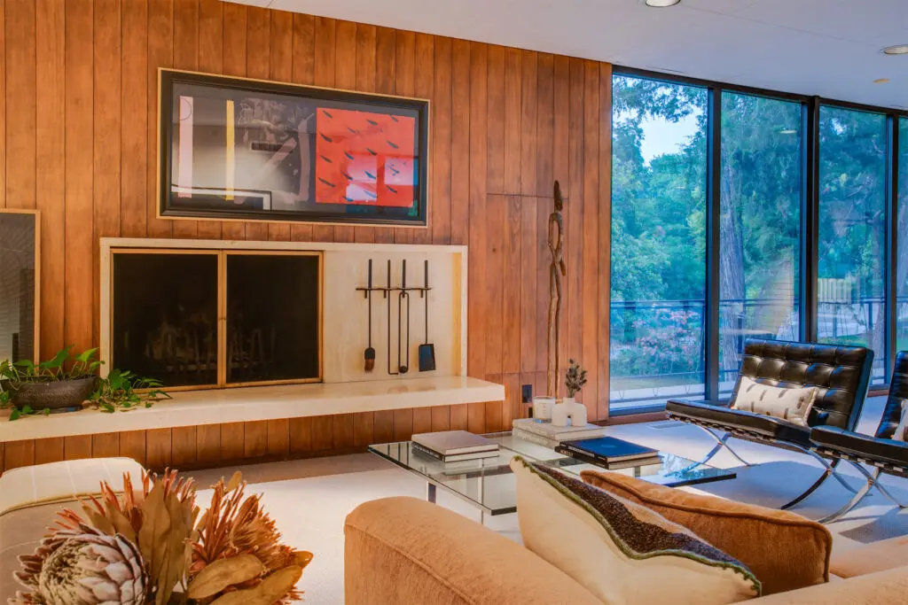Another spacious living area with custom cabinetry, wood-paneling, and floor-to-ceiling windows. 