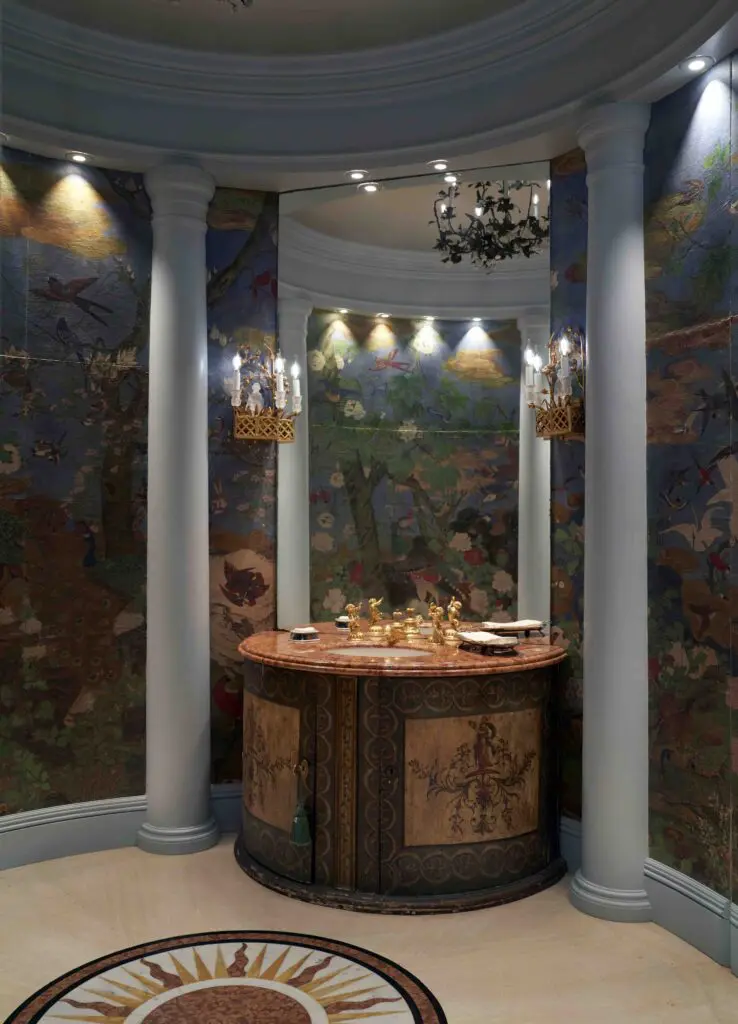 An antique round powder room off the foyer with original pilasters, hand-painted wallpaper, and sink, all salvaged intact from Rose Terrace. Hollywood architect Michael Morrison designed the sunburst marble floor pattern. (Photo by Pär Bengtsson)