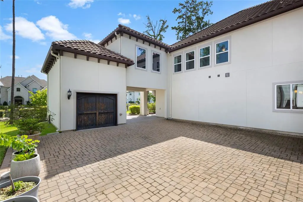 The pave-stone driveway leads to a three-car garage with extra space for additional parking. 
