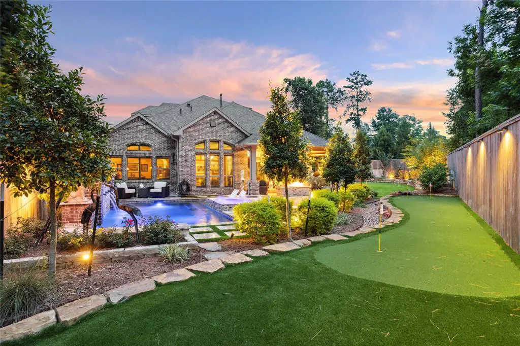 The fun continues in the backyard with a pool, putting green, and a summer kitchen. 
