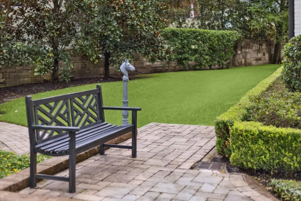 The stone patio overlooks a ravine filled with greenery to the side of the house.