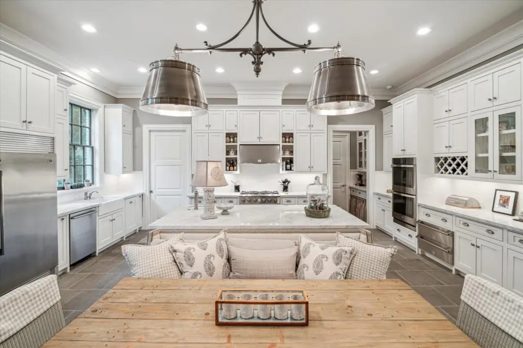 The gathering kitchen has ample cabinet space, marble countertops, and a dining ledge.