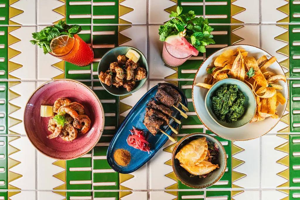 A vibrant aerial view of a beautifully arranged table spread, showcasing a delightful selection of West African dishes. Each plate invites a culinary journey through the rich flavors and traditions of Nigerian cuisine. (Photo by StuffBenEats)