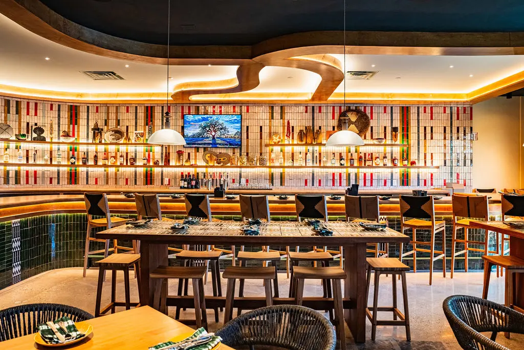 The bar and community tables pay tribute to the traditional West African woven fabric, Aso Oke, featuring a pattern designed by Nigerian American textile designer Shade Akanbi. (Photo by StuffBenEats)