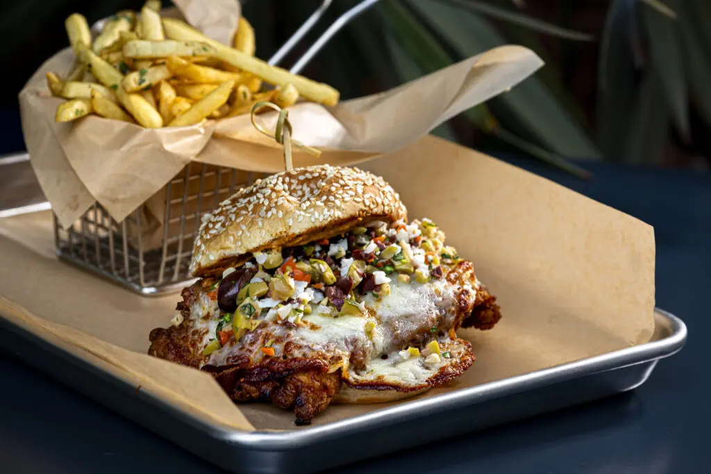 The menu also features items you can eat with your hands, such as this fried chicken muffuletta. (Photo by Jenn Duncan)