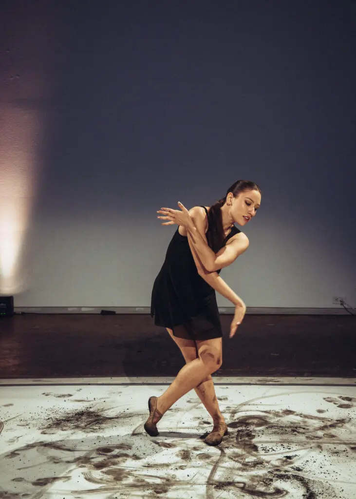 For this performance (which took place on three different pieces of paper in the large gallery), the group decided to create art on paper by putting charcoal on the dancers' feet. (Photo by Ethan Rios)
