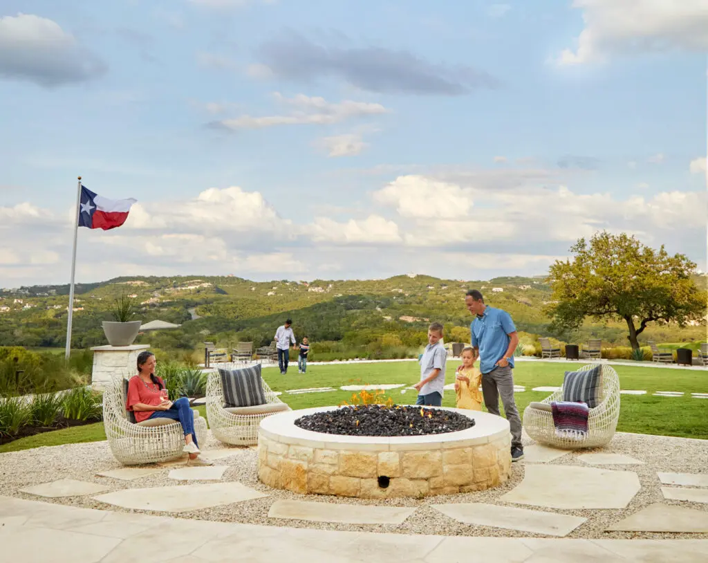 At Omni Barton Creek, guests can unwind in rocking chairs on the wraparound porch overlooking crackling firepits, or savor a drink at Jim Bob's richly wooded lounge where live music fills the weekends. (Photo by Sidekick Creative)