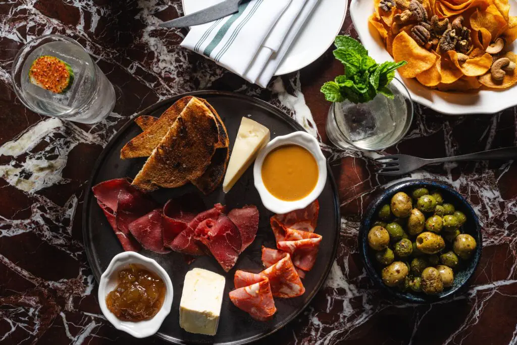 A few small bites offered on the menu at the newly reimagined Andiron Grill & Patio from a meat and cheese plate, chips and nuts, to grilled olives. (Photo by Michael Anthony)