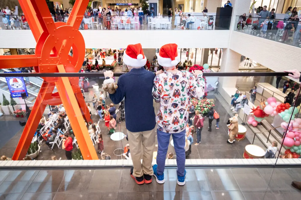Two kids overlook a packed NorthPark Center at Breakfast with Santa Spectacular. (Photo by Kim Leeson)
