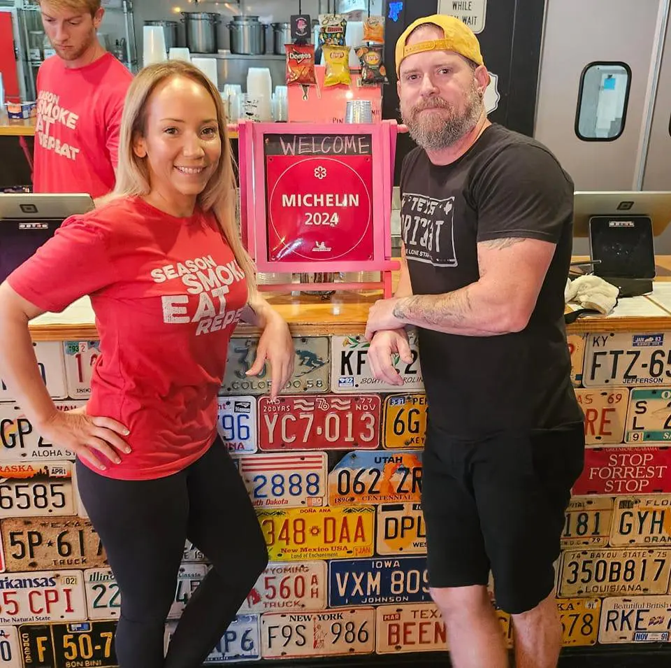 Will and Nichole Buckman of Corkscrew BBQ pose in front of their Michelin star award. (Photo courtesy Corkscrew BBQ)