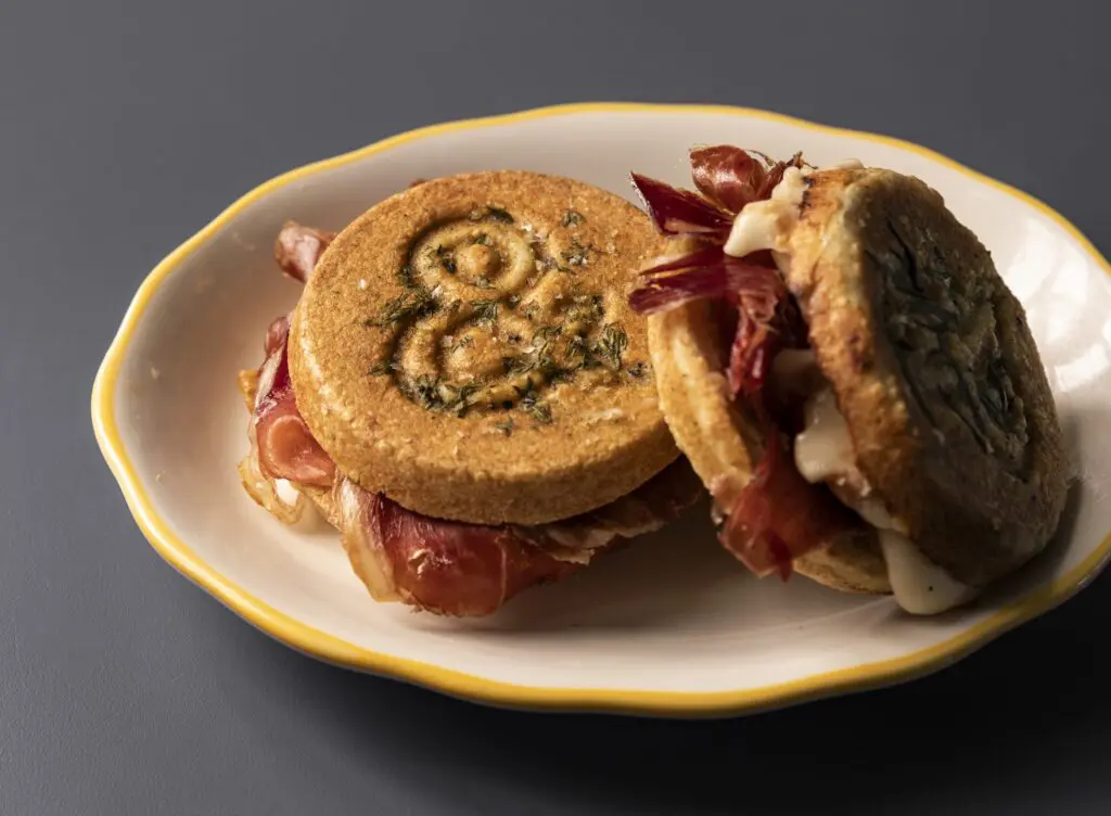 Lee's tigelle pressed sandwich is a housemade flatbread similar to an English muffin layered with ham, sliced apples, honey, and taleggio cheese ($11). (Photo by Julie Soefer)