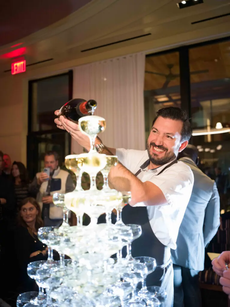 Chef Aaron Bludorn fills the champagne tower in the ballroom above his new restaurant Perseid at Hotel Saint Augustine. (Photo by Daniel Ortiz)