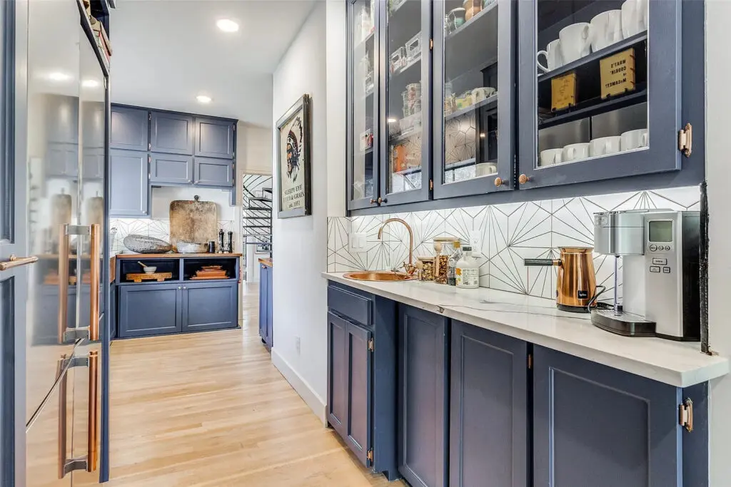The appliances and high-end finishes in the eat-in chef's kitchen (complete with blue cabinets and exposed shelving) make it appear large and luxe.