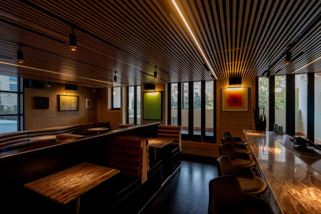 Brittany Vaughan of Garnish Design reimagined Lee's with chrome-accented ebony-colored wainscotting, soft black leather accents, gray velvet and directional lighting. (Photo by Carla Gomez)