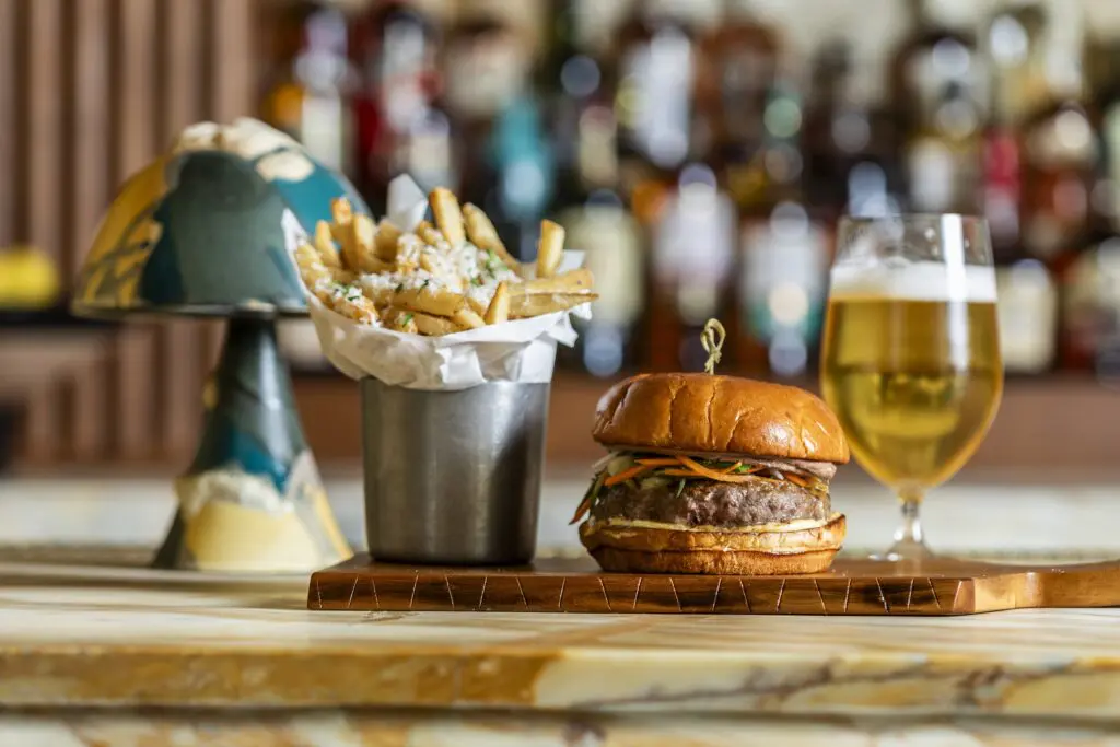 Even more common-sounding choices on the all-day menu are far from ordinary. The St. Augustine burger is layered with duck-liver mousse, pickled carrots and cucumbers, and Kewpie mayo on brioche ($23). Photo by Julie Soefer.