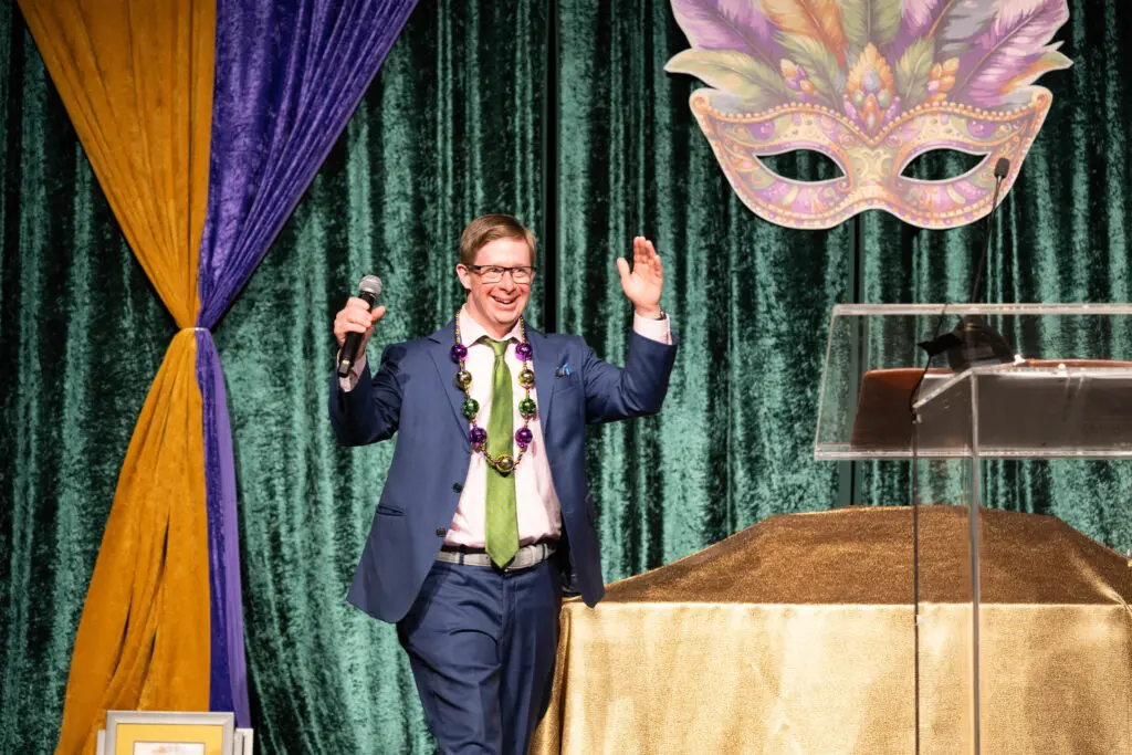 Austin Hanson takes the stage at Camp for All's Mardi Gras themed Krewe de Camp gala (Photo by Daniel Ortiz)