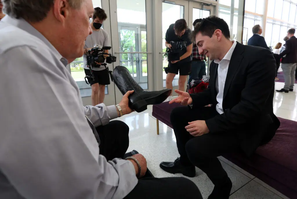 Competitor Denis Linnik is fitted for a new pair of boots at orientation for The Sixteenth Cliburn International Piano Competition at the TCU Music Hall in Fort Worth, Texas. (Photo by Richard Rodriguez)