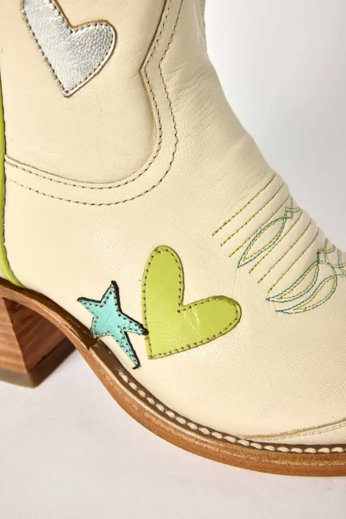 The boot features charming heart details that add a playful twist to an iconic Western silhouette.