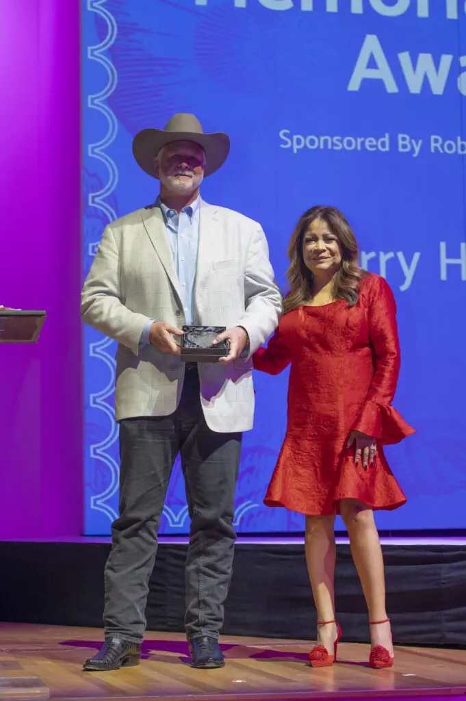 Preston Hagman accepting Memorial Hero Award for father Larry Hagman with emcee Clarice Tinsley (Photo by Tamytha Cameron)