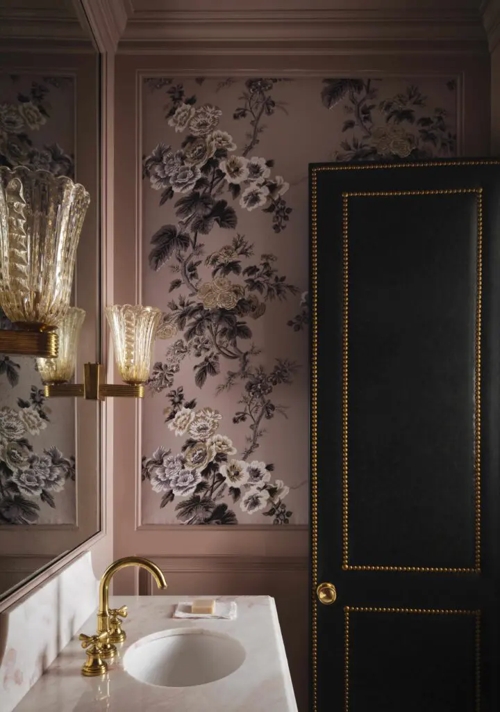 A powder bath wallpaper is Pyne Hollyhock by Schumacher. Custom door in Brentano leather from Pholio Co. Vintage Murano sconces.  (Photo by Douglas Friedman)
