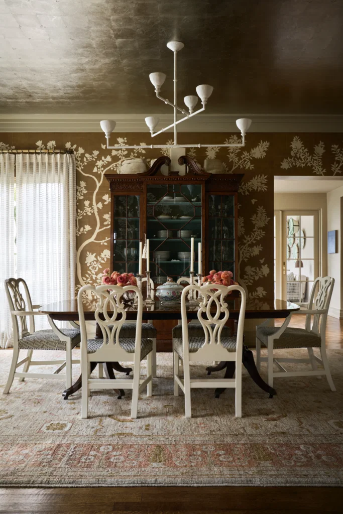 The dining room’s antique table, breakfront, and Baker chairs belonged to Shelby Wagner’s grandmother. Antique rug inherited from his mother. Walls covered in Gracie Tobacco Leaf print. Phillip Jeffries Platinum Leaf paper on ceiling. Stephen Antonson plaster chandelier from Wells Abbott. (Photo by Pär Bengtsson)