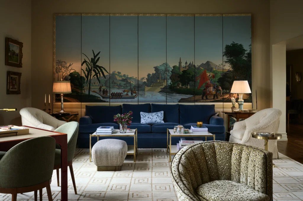 In the living room, vintage Zuber panels from Muse on Slocum. Shelby Wagner designed the sofa in Fox Linton velvet. Frederick P. Victoria & Son brass-and-parchment coffee tables. Vintage bouclé club chairs and pouf. In foreground, the chair in original Clarence House cut velvet belonged to Wagner’s mother. Cameron Collection game table, Doris Leslie Blau rug for Stark. (Photo by Pär Bengtsson)