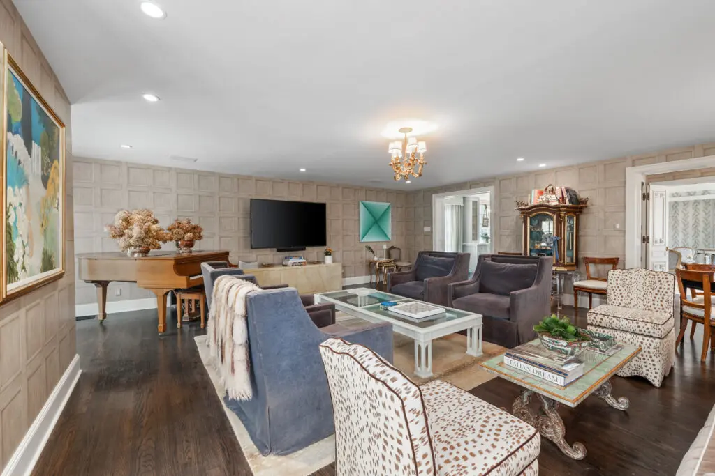 Paneled walls and rich wood floors bring warmth and sophistication to the expansive main living area.  (Photo by Freeze Media FW)