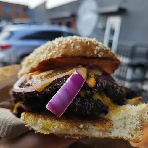 Panther City’s brisket smashburger delivers bold flavor with thick-cut red onion, pickles, and tangy house sauce on a toasted sesame bun. (Photo by Edward Brown)