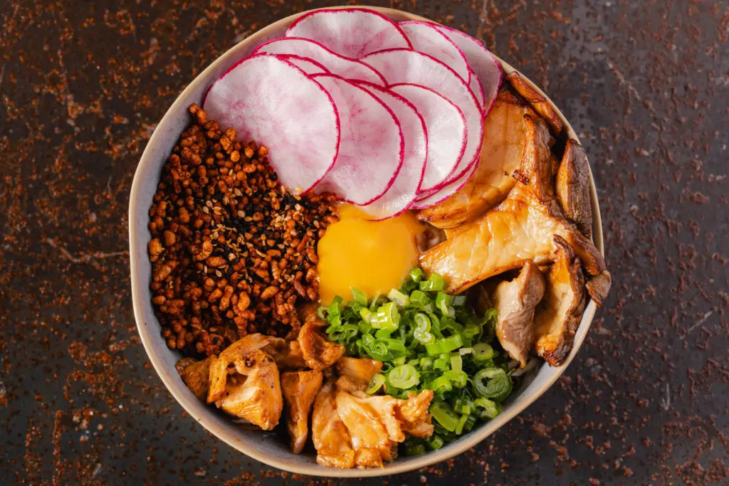 The popular Japanese dish, donburi ($20), is a warm, comforting vegetarian bowl filled with sauteed King trumpet and hedgehog mushrooms, radish, caramelized onions, and an egg over Koshihikari rice, seasoned with a puffed rice furikake. Photo by Michael Anthony.