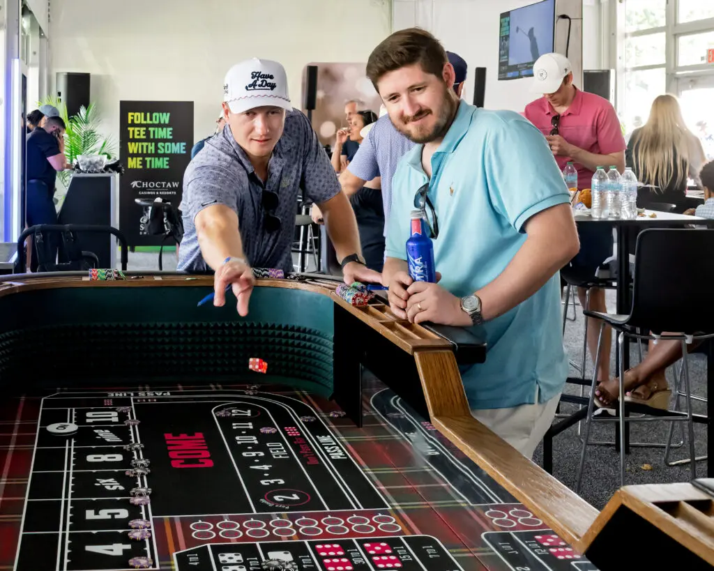 Guests test their luck at the craps table inside the Choctaw Club, where casino games added extra flair to the golf weekend. (Photo by Walt Burns)