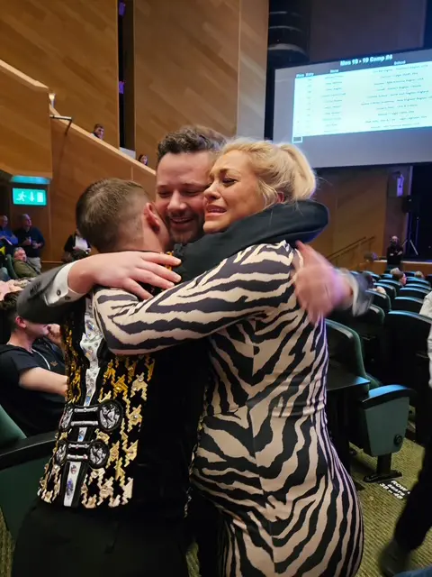 Michael Pixton, left, celebrates with coaches Owen Barrington and Laura Cass-Barrington during the 2025 World Irish Dance Championships in Ireland. (Photo by Cass-Barrington Academy)
