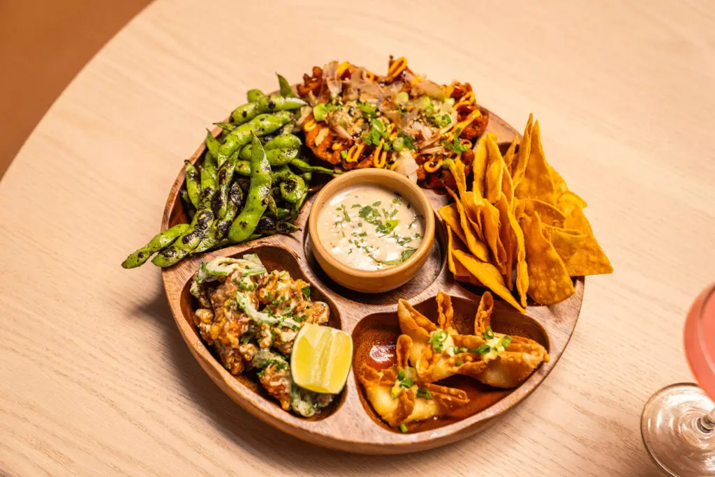 The Cure platter features crab rangoon, hatch chili queso, salted charred edamame, popcorn chicken, and Yummy fries. (Courtesy)