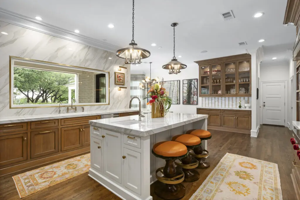 A chef-worthy kitchen balances warmth and precision with Neolith countertops, WaterStreet Brass hardware, and a custom onyx table framed by mid-century inspired pendants. (Freeze Media)
