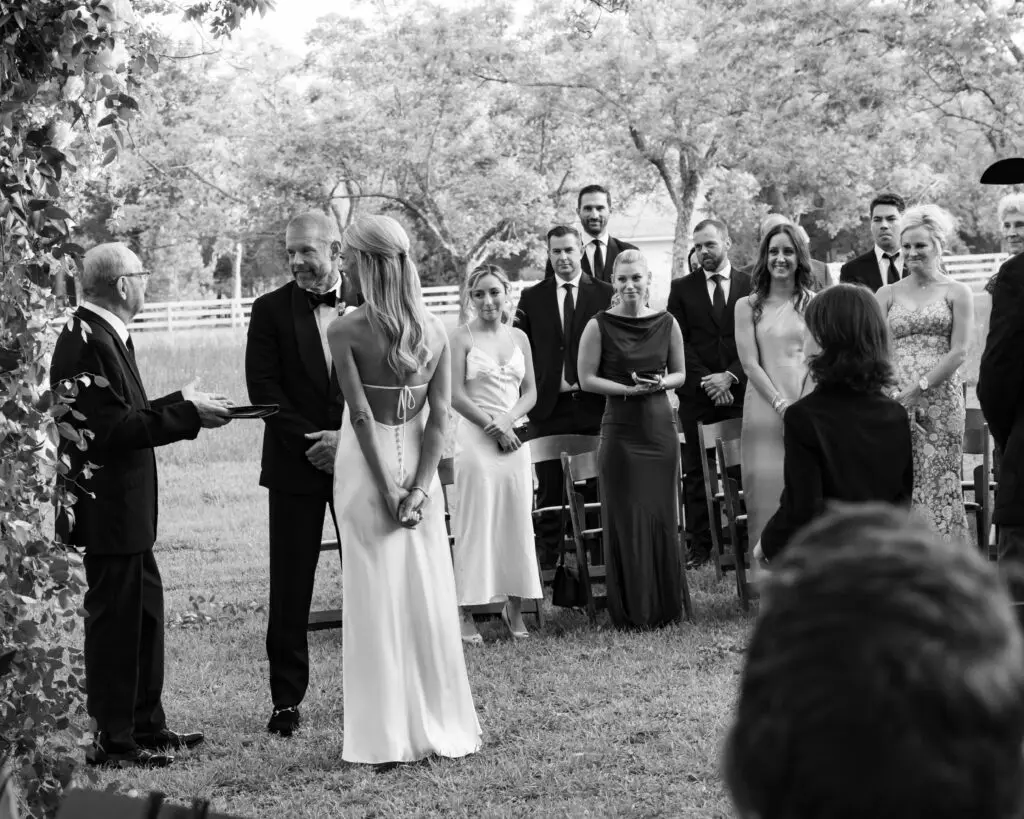 Madeline McCrann and Toby Potter stand at the altar at Chandelier Grove as their guests look on. (Photo by Jen Durst for Jen Elizabeth Photography)