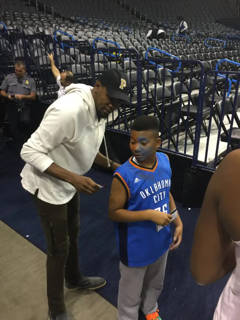 Kevin Durant signs a young Chase McCarty's jersey.