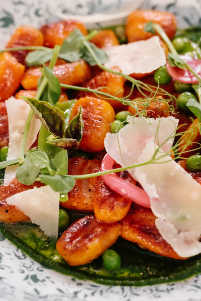 Entrees include the vegetarian-friendly hand-rolled carrot gnocchi, where steamed and roasted carrots take the place of the traditional potatoes ($24). The exterior of these little dumplings is seared, then cooked in white wine and tossed with English peas in a butter-enriched herb pistou. (Photo by Photos by Jenn Duncan)