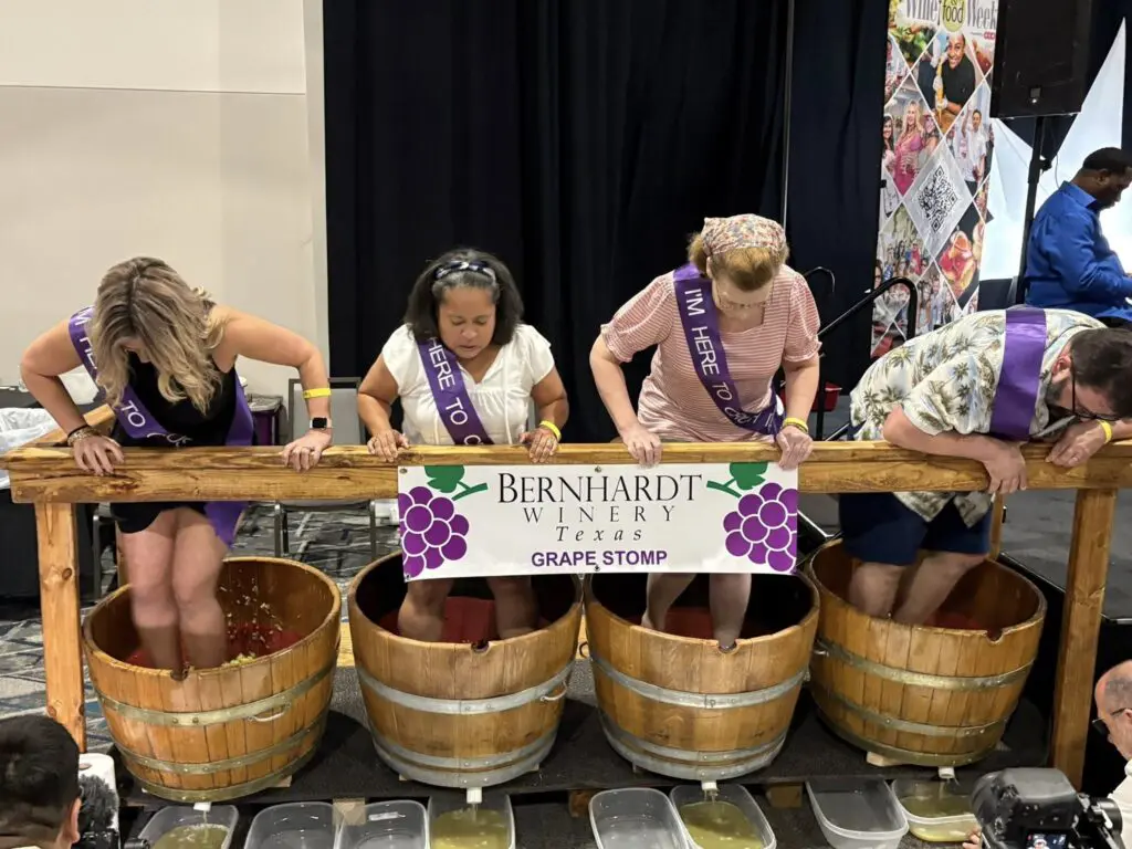 Attendees get their feet dirty during the grape stomping competition hosted by Bernhardt Winery at Wine & Food Week. (Photo by Food and Vine Time Productions)