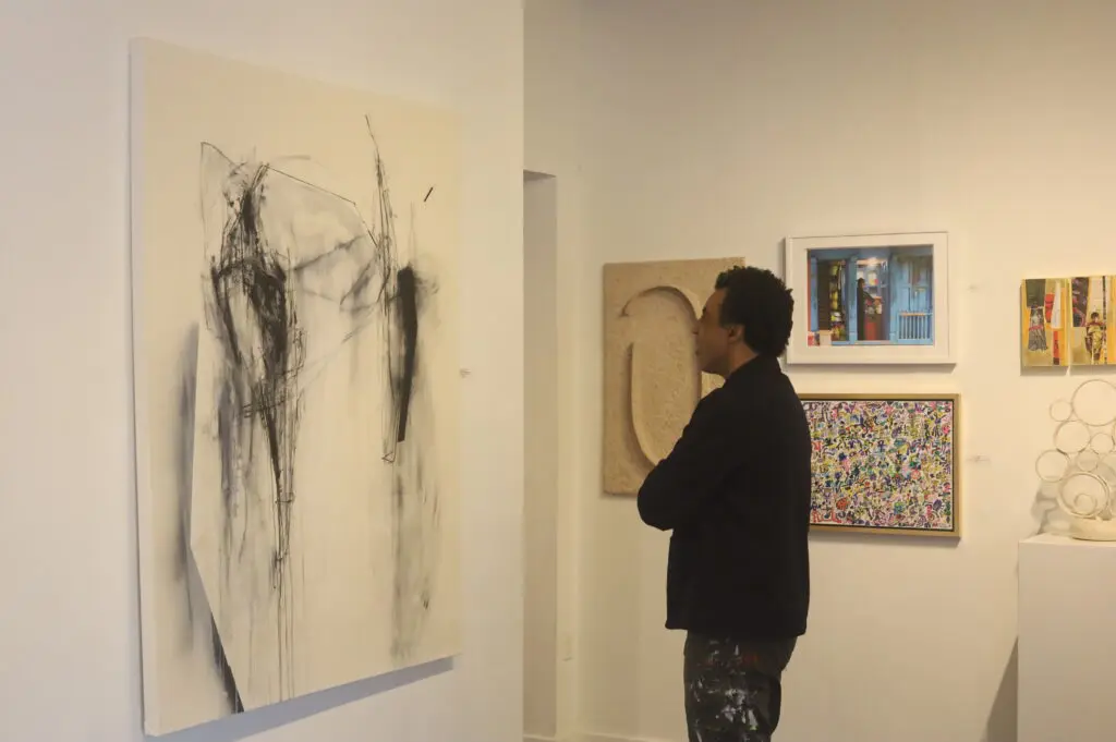 Artist Rick Lowe, co-founder and former executive director of Project Row Houses, views Lawrence Lange's acrylic, ink and charcoal on canvas work "A Once Proud and Noble Man" at Archway Gallery. Lowe juried Archway's 17th Annual Juried Exhibition  recently. (Courtesy Archway Gallery, Houston)