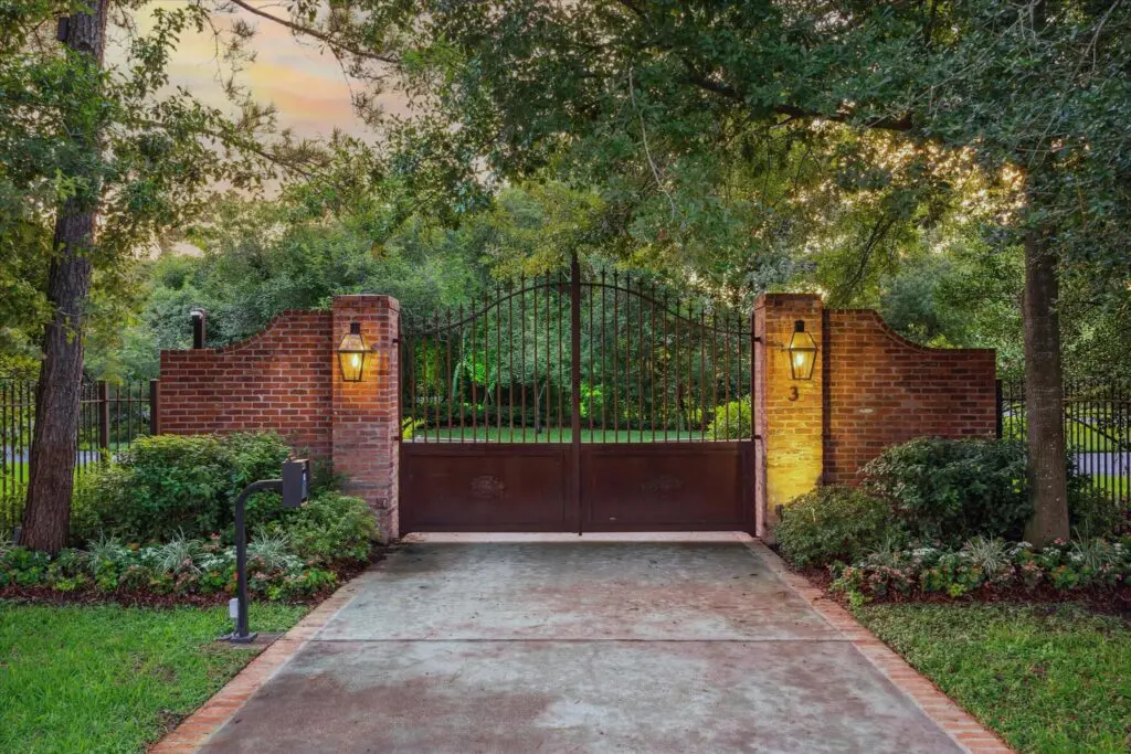 The wrought iron gate, fencing and thick greenery offer discreet privacy at 3 E Rivercrest Drive. (Photo by TK Images for Martha Turner Sotheby’s International Realty)