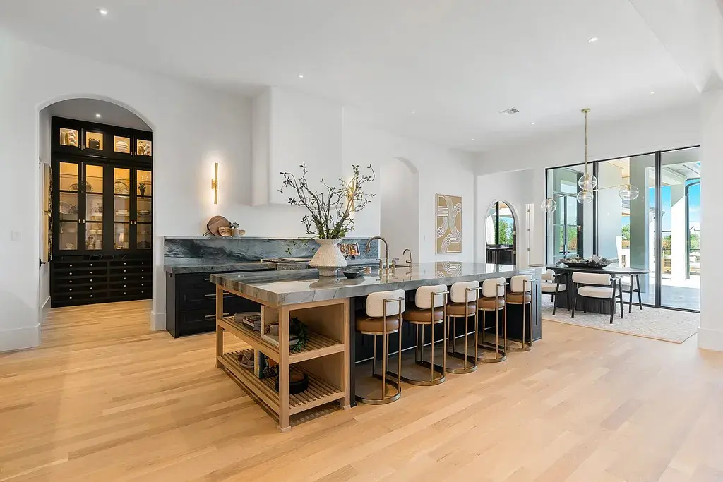 The chef’s kitchen centers on a striking waterfall-edge island and hidden butler’s pantry. (Courtesy)