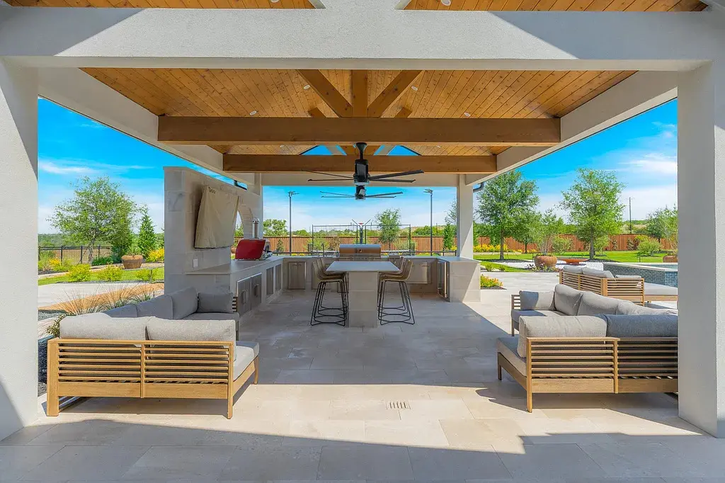 A covered patio with fireplace and lounge seating extends the living space seamlessly outdoors. (Courtesy)