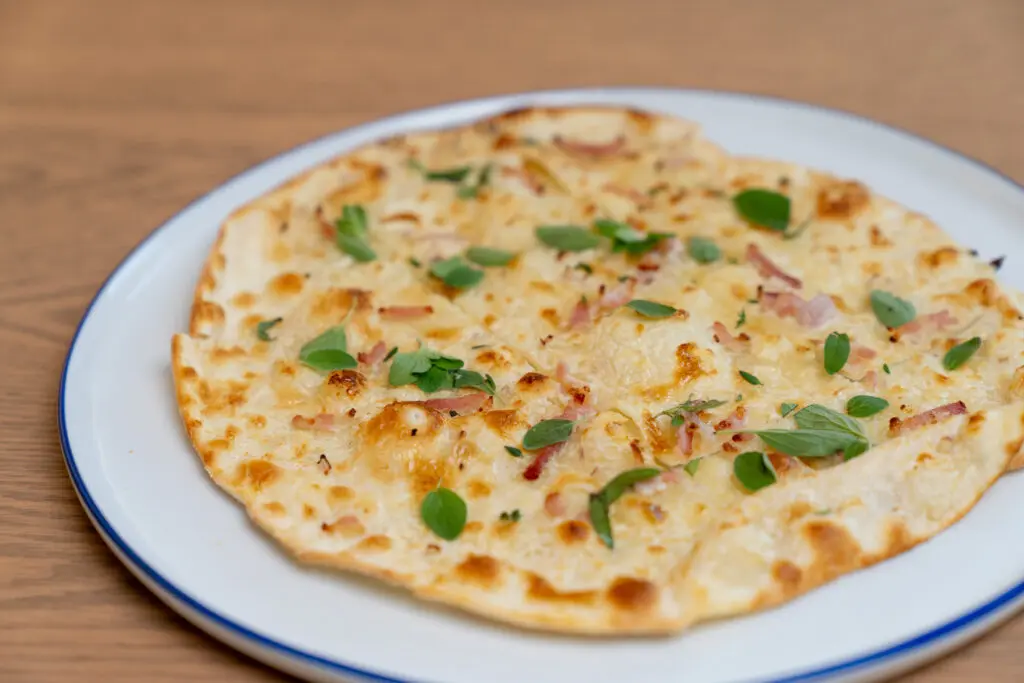 I was lured to order the in-season heirloom tomato pie ($18), but what I really loved was the shareable tarte flambée ($18). After Gawl attended a wedding in the Alsace region (the northeastern France region with a strong Germanic cultural influence) and indulged in numerous iterations of the classic dish there, he recreated the unleavened cracker-like crisp crust stateside, topping it with the traditional lardons of bacon, shallots, and a creamy yet tangy cow’s-milk fromage frais. Photo by Carla Gomez.