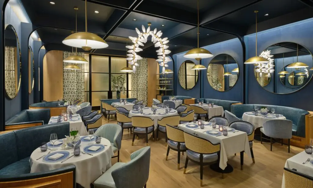 Bathed in deep navy and framed by velvet drapes, The Blue Room at The Crescent Hotel offers an intimate, modern setting with sculptural lighting and contemporary art. (Photo by Jason Dewey and The Crescent Hotel Fort Worth)
