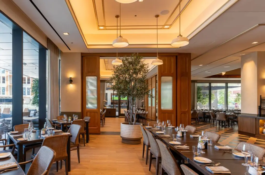 Farena’s airy dining room at Loews Arlington Hotel blends modern elegance with warm wood tones and natural light. (Photo by Farena)