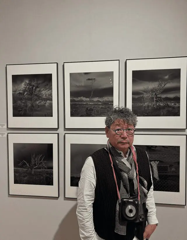 Osamu James Nakagawa stands with prints from his series "Witness Trees + Indelible Structures" during Paris Photo 2025 in Paris, France. (Photo courtesy Osamu James Nakagawa)