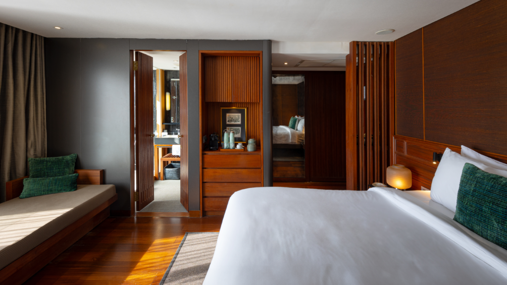 Warm wood and dark stone details define the Aqua Mekong suites, each with floor-to-ceiling windows and a private terrace overlooking the river. (photo courtesy of Aqua Expeditions)