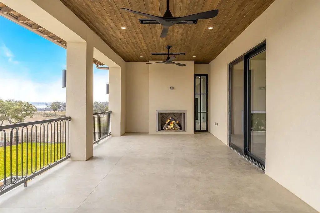 The covered balcony includes a fireplace, wood-paneled ceilings, and elevated views overlooking the surrounding landscape near Eagle Mountain Lake. (Courtesy)