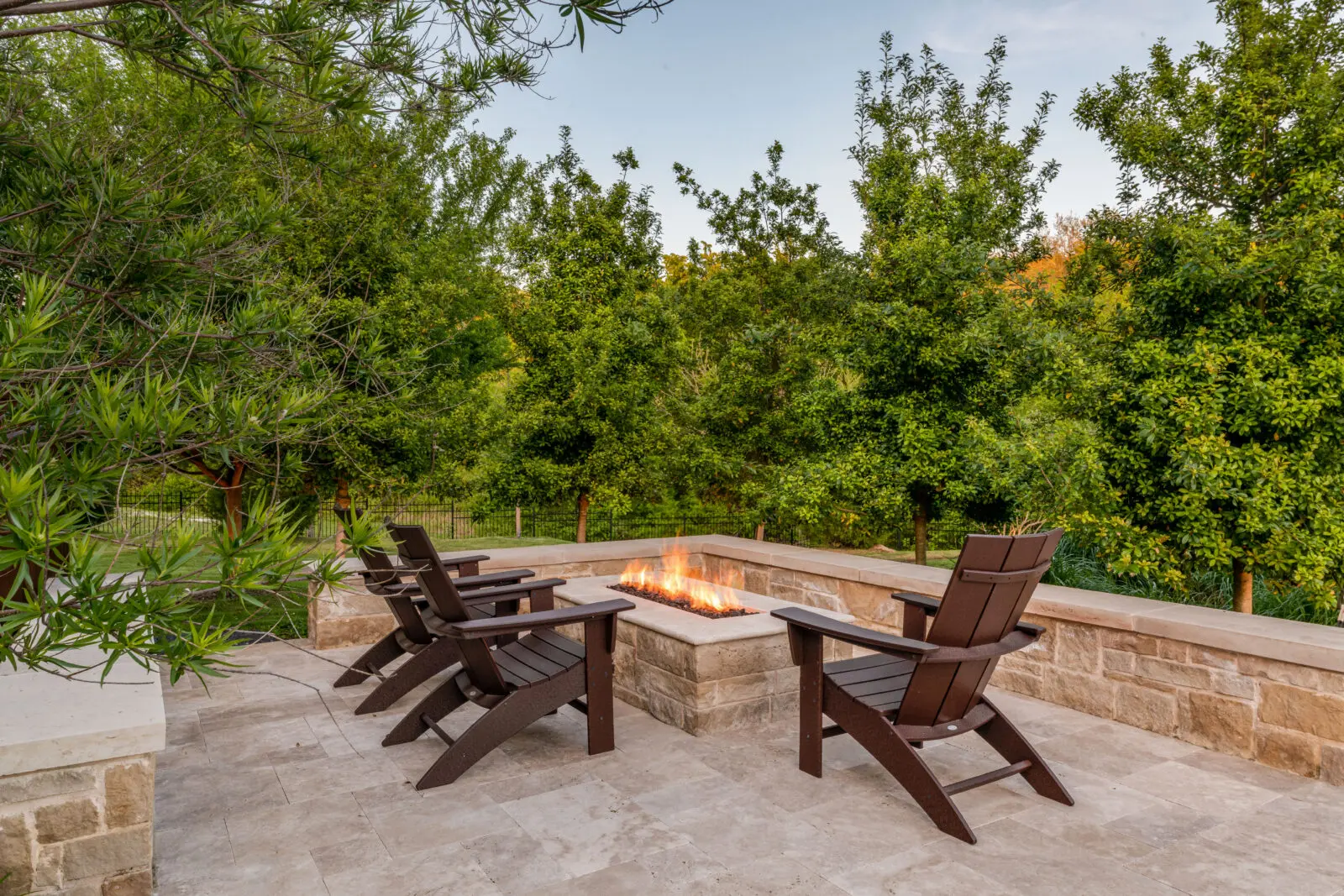 The resort-like backyard includes a fire pit. (Photo by Costa Christ / Compass)
